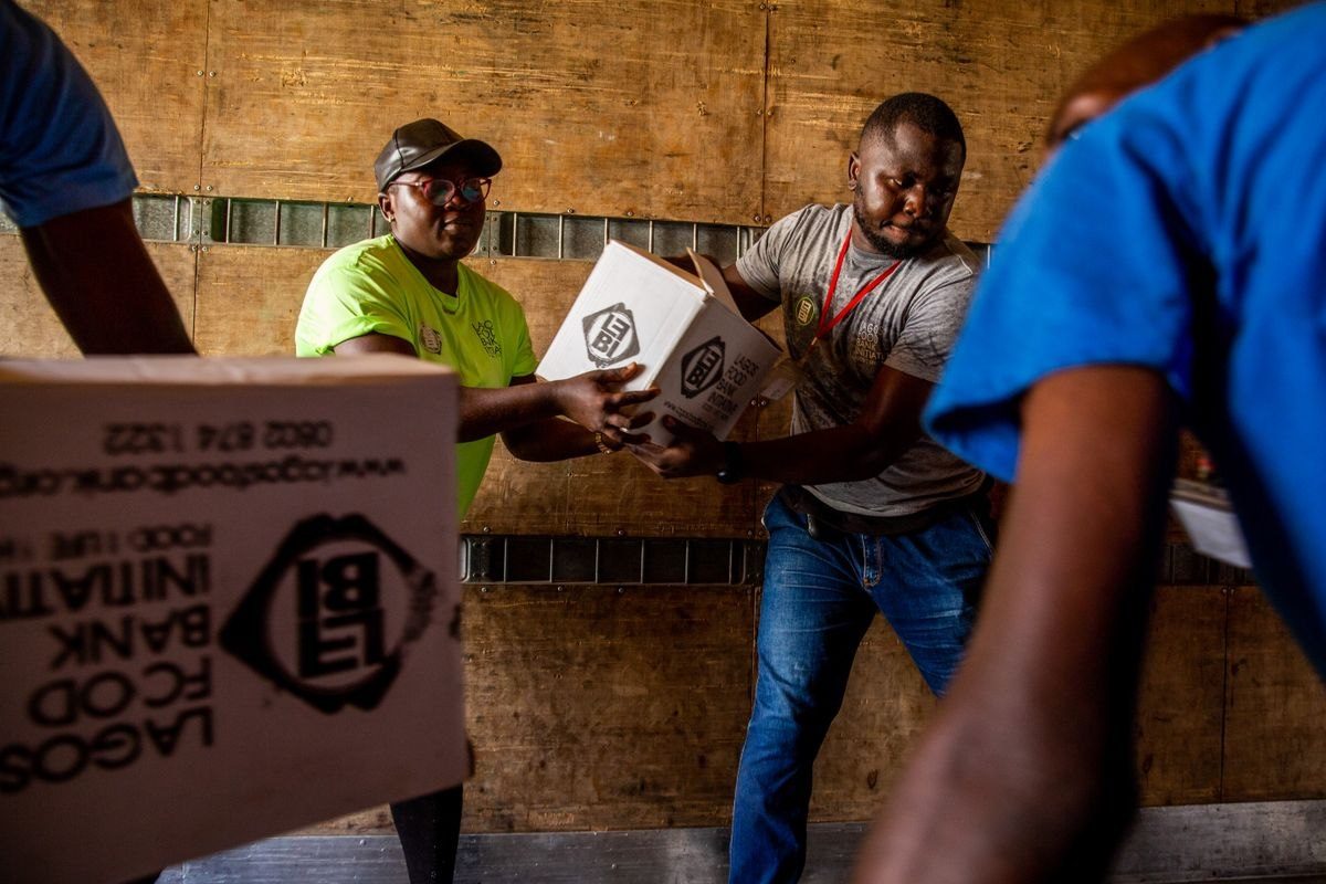 Photo d’illustration : des membres de la Lagos Food Bank Initiative transportent des cartons. Cette scène illustre le travail logistique.